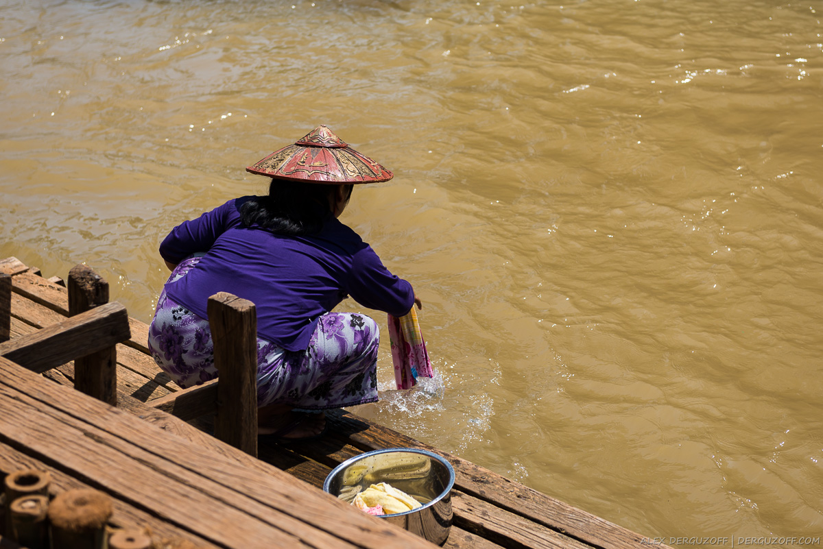 Женщина стирает белье в реке
